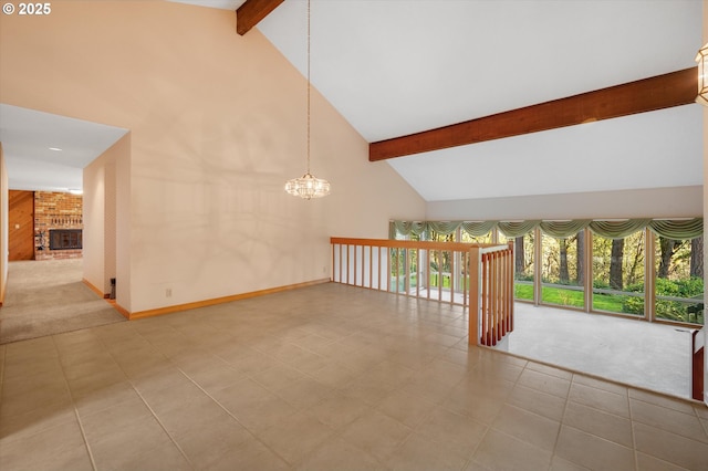 carpeted spare room featuring a chandelier, high vaulted ceiling, a brick fireplace, and beam ceiling