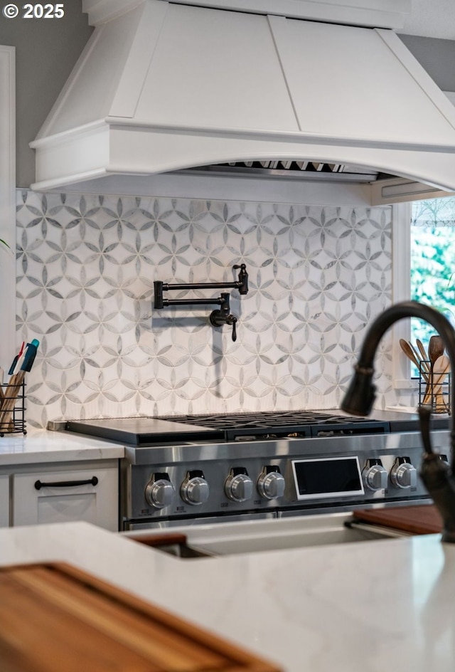 interior details with light countertops, stove, backsplash, and white cabinets