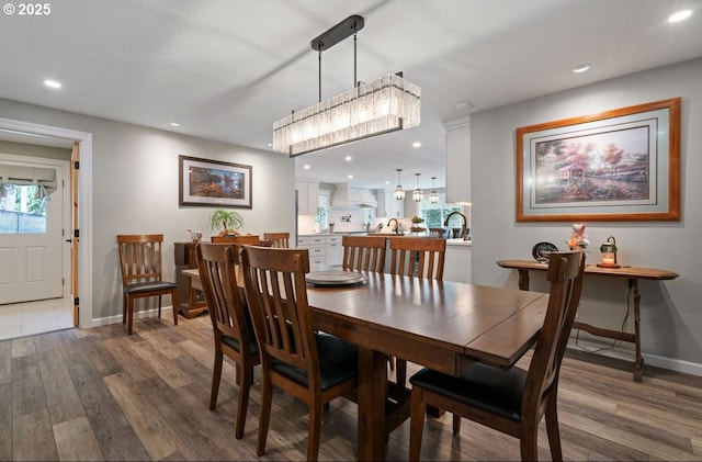 dining room featuring baseboards, wood finished floors, and recessed lighting