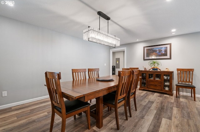 dining room featuring recessed lighting, wood finished floors, electric panel, and baseboards