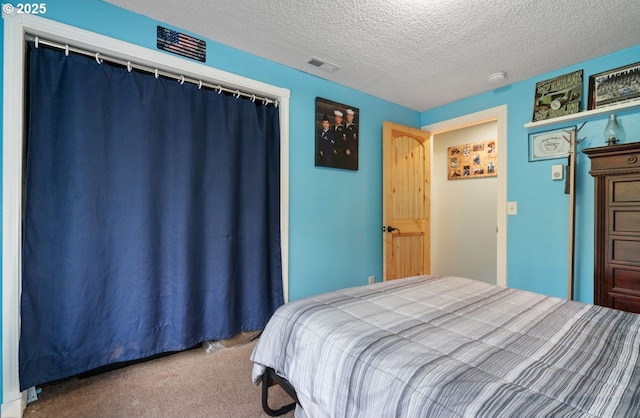 carpeted bedroom with a closet, visible vents, and a textured ceiling