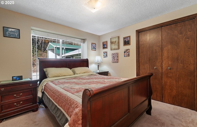 bedroom with a textured ceiling, a closet, and light colored carpet