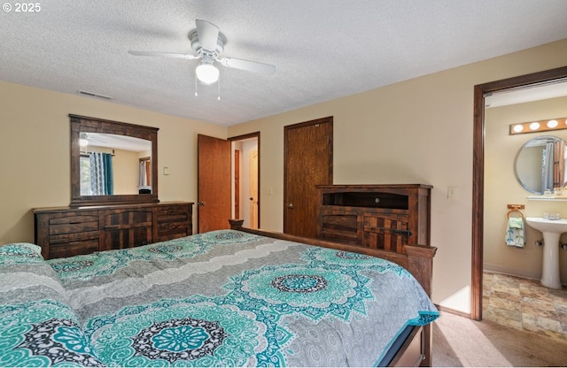 bedroom with a textured ceiling, carpet floors, visible vents, and a ceiling fan