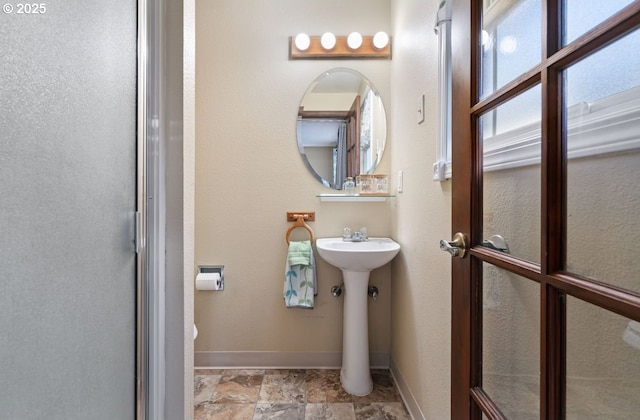 bathroom with stone finish floor and baseboards