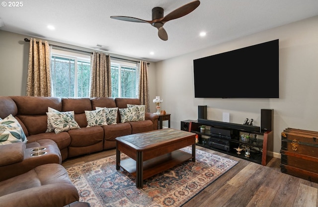 living room featuring ceiling fan, baseboards, wood finished floors, and recessed lighting