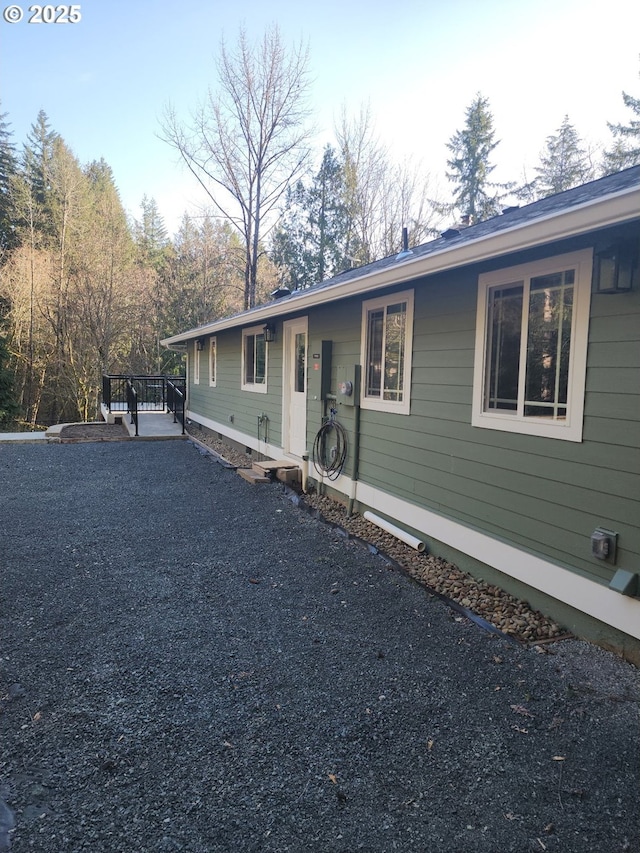 view of front of property featuring gravel driveway and a deck