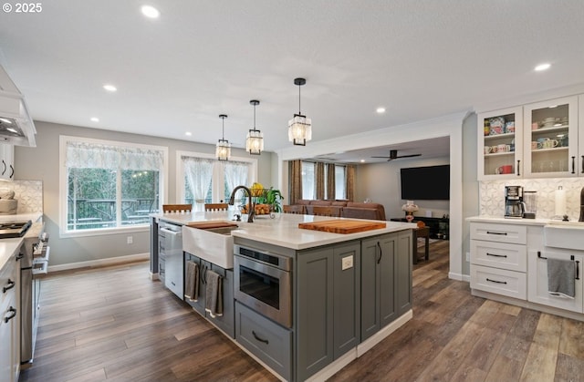 kitchen with stainless steel appliances, gray cabinets, dark wood-style flooring, and light countertops