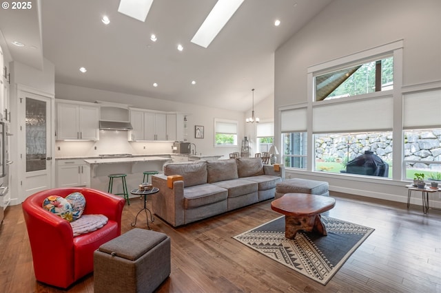 5786 NW Hood Loop, Camas, WA 98607 - living area featuring high vaulted ceiling, healthy amount of natural light, a skylight, a chandelier, and wood finished floors