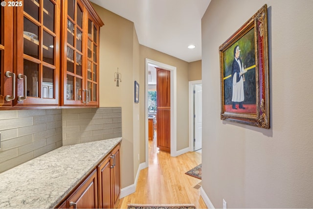 corridor with light wood-style flooring, recessed lighting, and baseboards