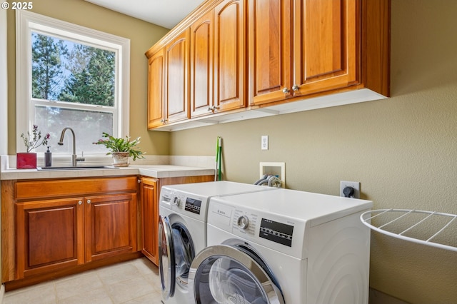 washroom featuring a sink, cabinet space, and independent washer and dryer