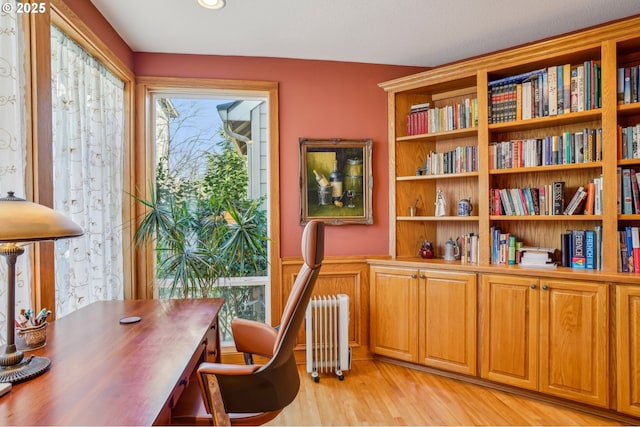 home office with light wood-style floors and radiator