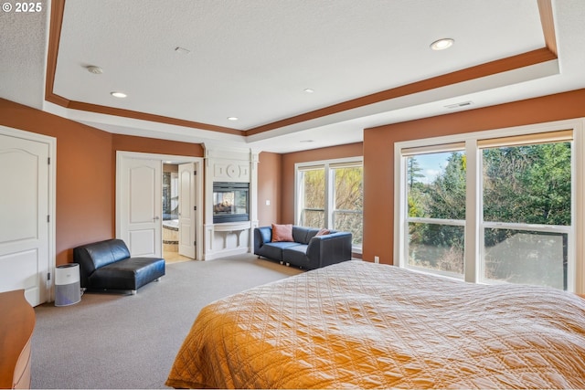 carpeted bedroom featuring visible vents, a textured ceiling, and a raised ceiling