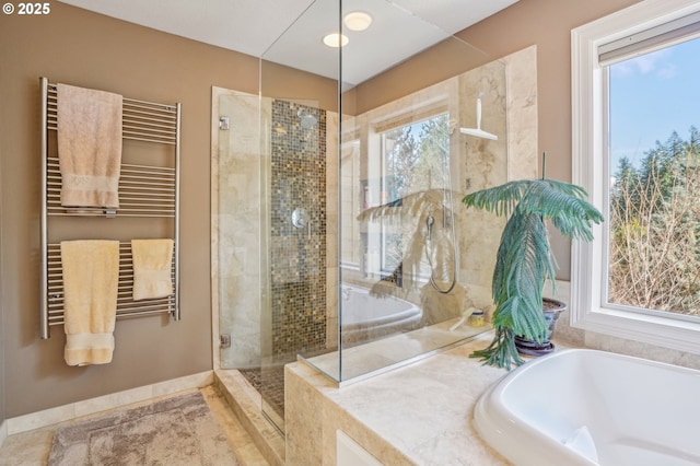 bathroom with radiator, a shower stall, tile patterned flooring, baseboards, and a bath