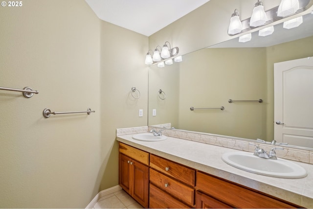 full bath with tile patterned flooring, double vanity, baseboards, and a sink