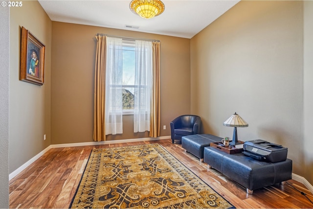 sitting room featuring visible vents, wood finished floors, and baseboards