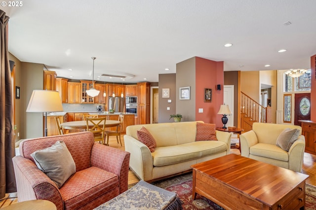 living area featuring recessed lighting, wood finished floors, and stairs