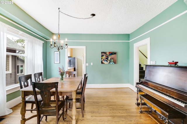 6308 SE 93rd Ave, Portland, OR 97266 - dining space with a textured ceiling, baseboards, a notable chandelier, and light wood-style floors
