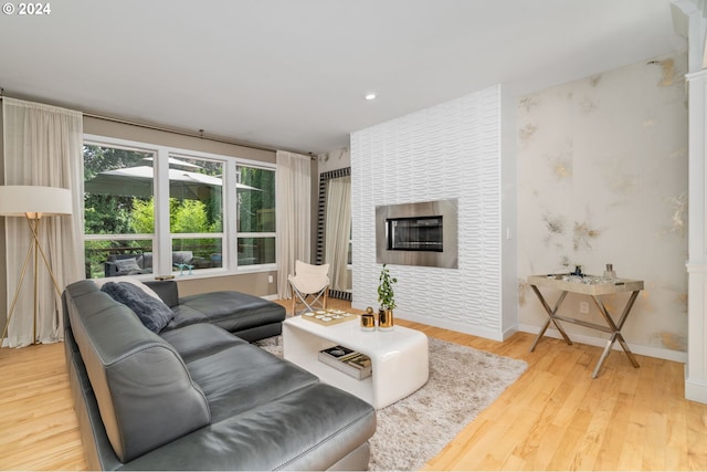 living area with recessed lighting, wood finished floors, baseboards, and a tile fireplace