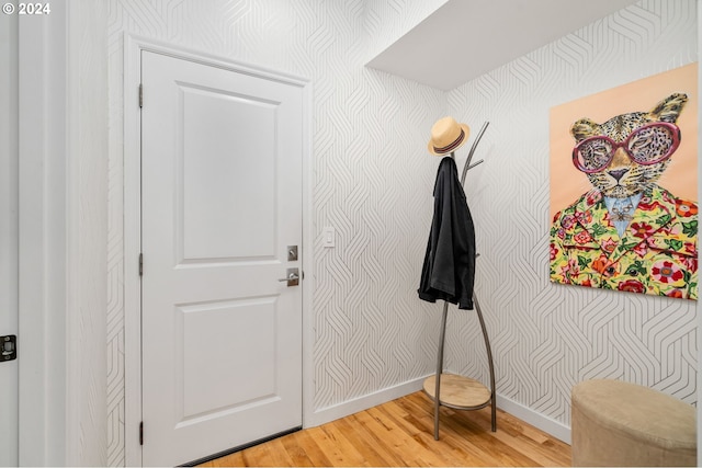 entrance foyer featuring baseboards, light wood-style floors, and wallpapered walls