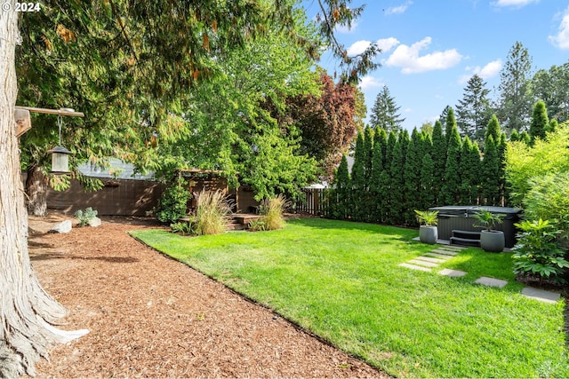 view of yard featuring a fenced backyard and a hot tub