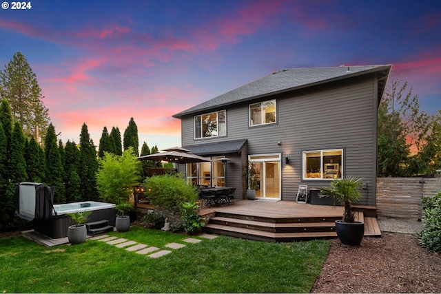 back of house featuring a deck, a hot tub, a yard, and fence