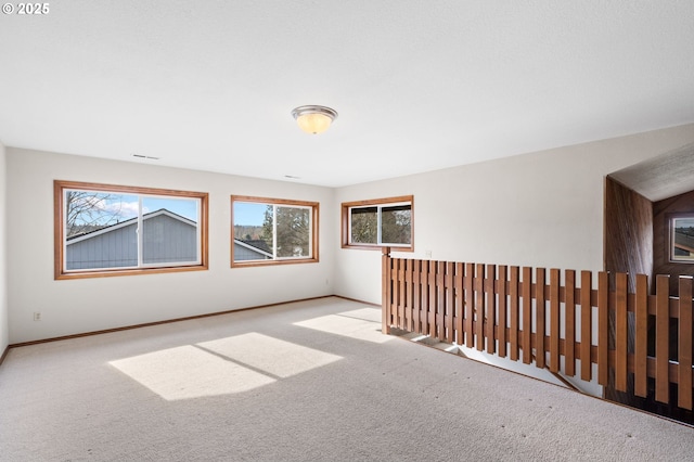 carpeted empty room featuring baseboards