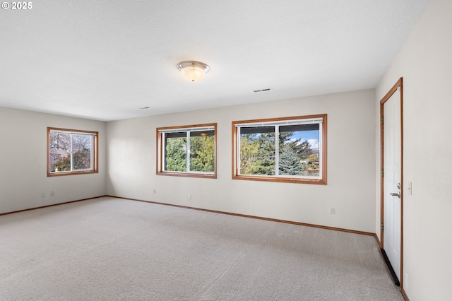 unfurnished room featuring light carpet, visible vents, and baseboards