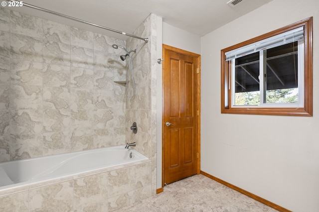 full bathroom with baseboards, visible vents, and tiled shower / bath