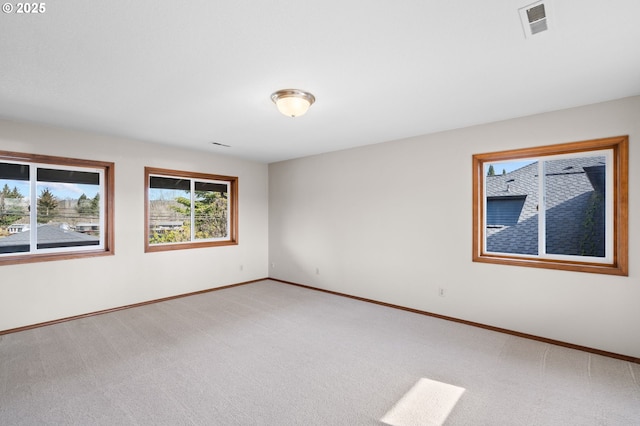 unfurnished room with light carpet, visible vents, and baseboards