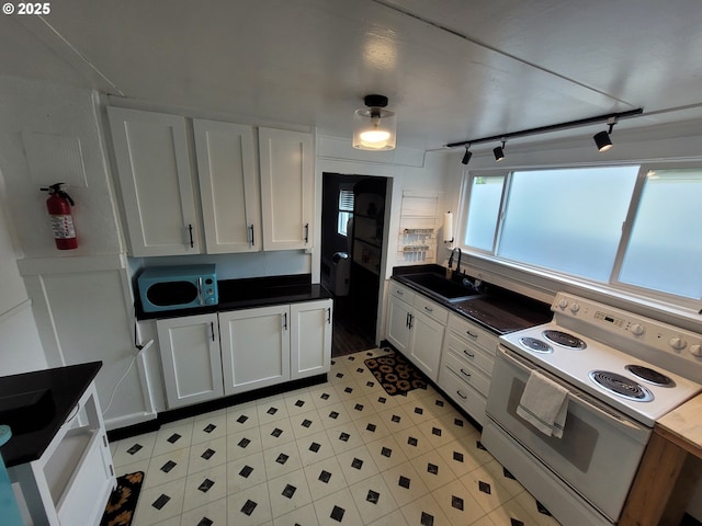 1875 W 18th Ave, Eugene, OR 97402 - kitchen featuring white cabinets, a sink, dark countertops, white electric range, and rail lighting
