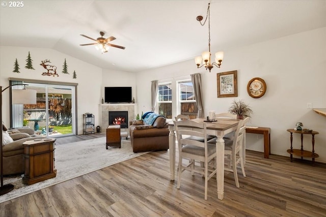 853 NE Cobblestone Ct, Prineville, OR 97754 - dining room with wood finished floors, lofted ceiling, a tiled fireplace, ceiling fan, and a chandelier