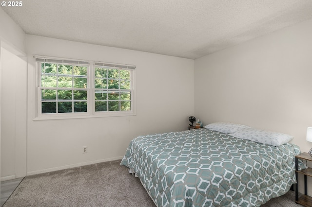 carpeted bedroom featuring baseboards and a textured ceiling