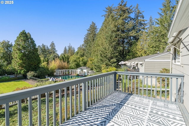 wooden deck with a lawn and an outdoor structure