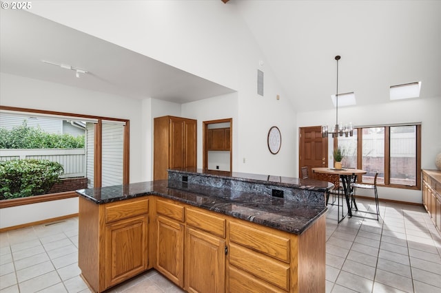 kitchen featuring a wealth of natural light, decorative light fixtures, a kitchen island, and light tile patterned floors