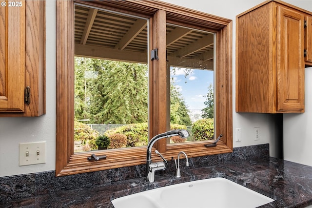 details featuring dark stone countertops, brown cabinets, and a sink