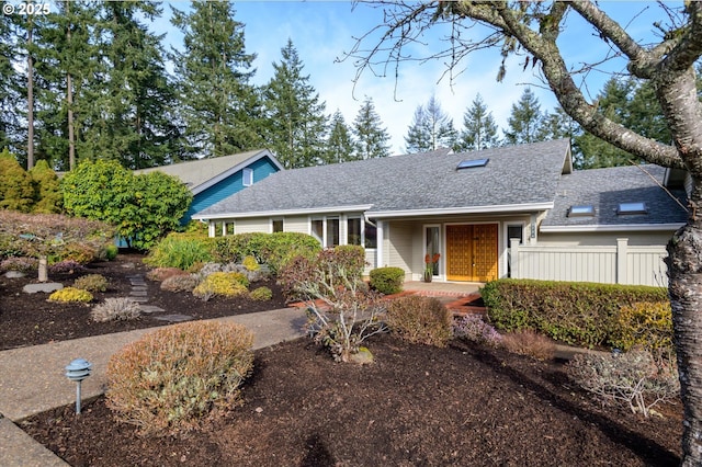 view of front of property featuring fence and roof with shingles