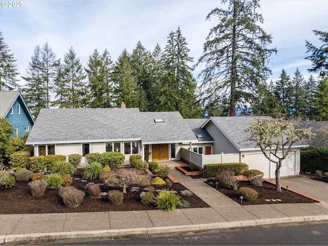 view of front of property with a shingled roof, driveway, and an attached garage