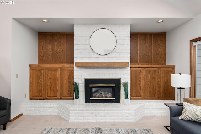 living area featuring light carpet, a brick fireplace, and recessed lighting