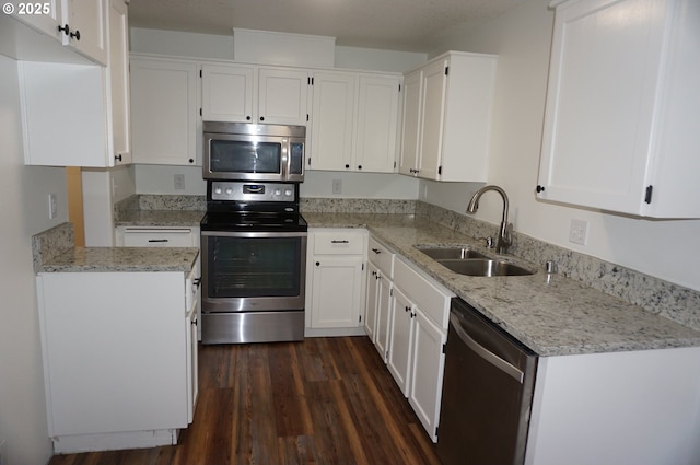 kitchen featuring dark wood-style floors, appliances with stainless steel finishes, a sink, and white cabinets