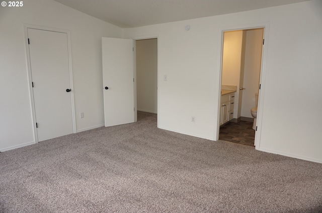 unfurnished bedroom featuring connected bathroom and carpet flooring