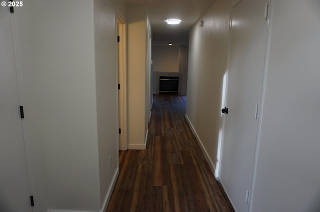 hallway featuring dark wood-style floors and baseboards