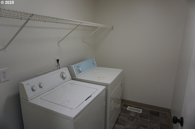 laundry area featuring laundry area, baseboards, visible vents, and washer and dryer