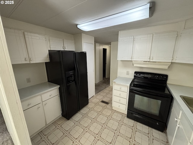 5336 Buckskin Bob, Florence, OR 97439 - kitchen with light floors, black appliances, under cabinet range hood, white cabinetry, and light countertops