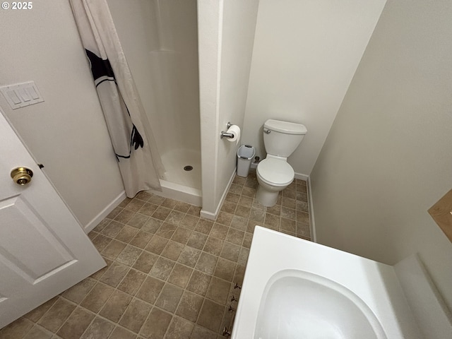 5336 Buckskin Bob, Florence, OR 97439 - bathroom with toilet, baseboards, a stall shower, and tile patterned flooring