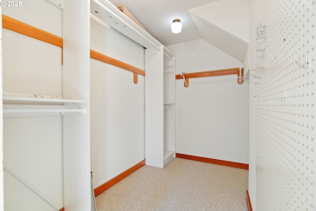 spacious closet with light colored carpet and lofted ceiling