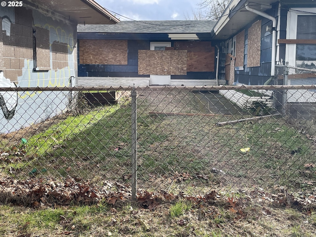 view of home's exterior featuring a shingled roof and fence