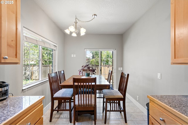 3647 Lodenquai Ln, Eugene, OR 97404 - dining room featuring plenty of natural light, a chandelier, light tile patterned floors, and baseboards