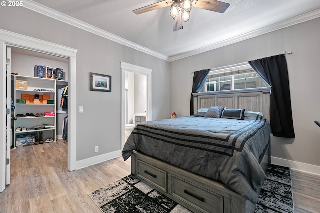 3647 Lodenquai Ln, Eugene, OR 97404 - bedroom with baseboards, crown molding, a walk in closet, light wood-style flooring, and a closet