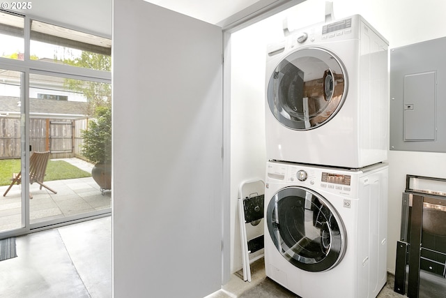 clothes washing area featuring laundry area, stacked washer / drying machine, and electric panel