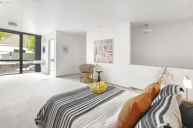 bedroom with visible vents, baseboards, floor to ceiling windows, and carpet